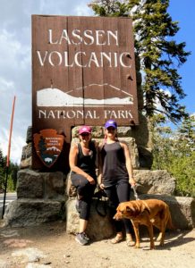 two people in front of a dog friendly national park sign