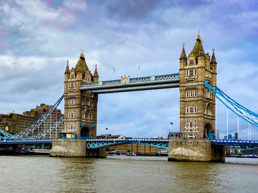 image shows the Tower Bridge across the Thames River, with an ominous sky