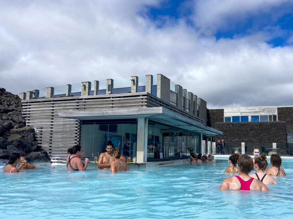 image shows a number of people crowded around a swim up bar in the blue thermal mineral waters of the blue lagoon