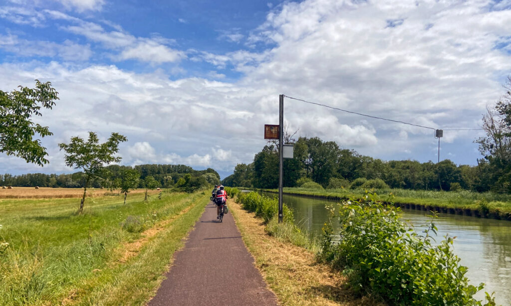 A beautiful day riding along the canal towpath towards the first brewery in Strasbourg, Alsace, surrounded by greenery and calm waters.