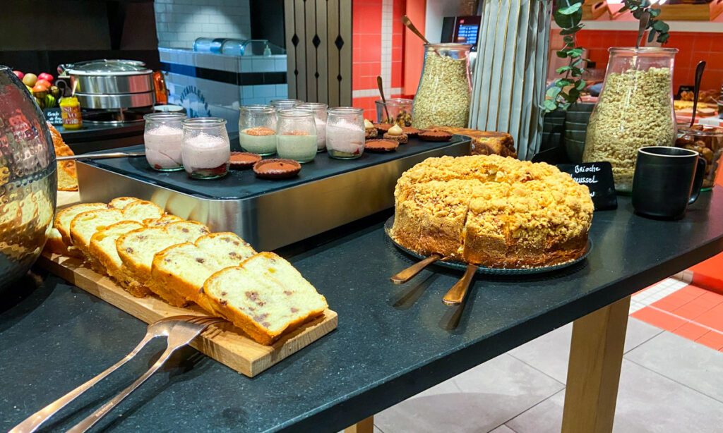 A continental breakfast with handmade pastries and yogurt is laid out on a table.